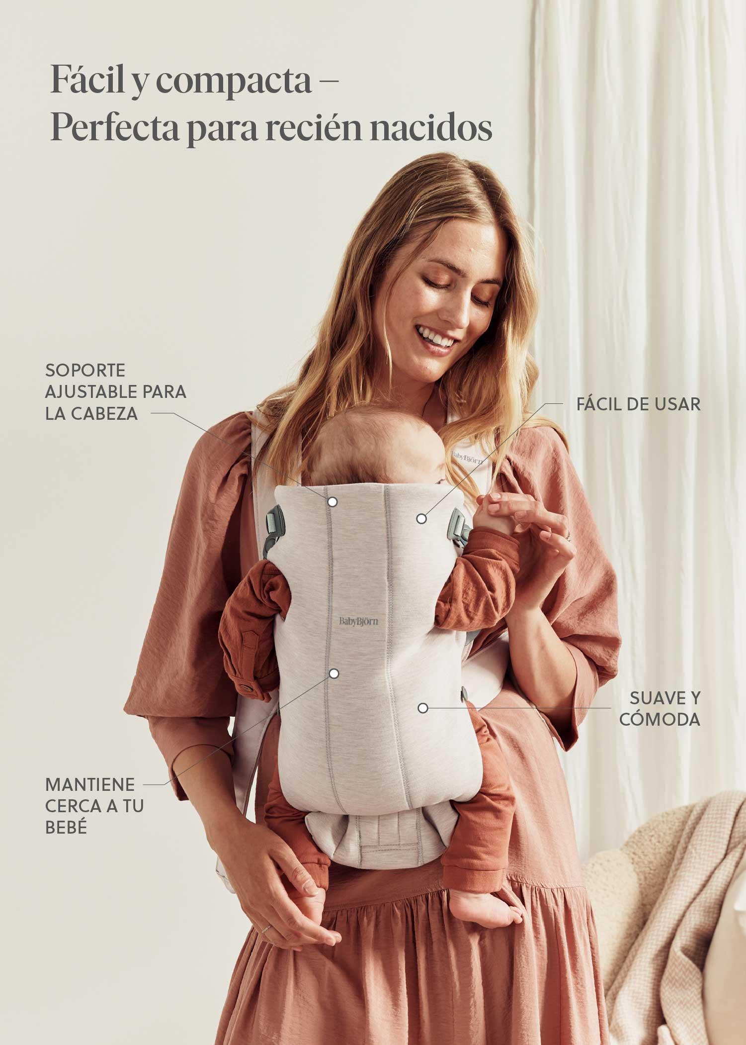 A woman smiles while holding a baby in a light-colored baby carrier. Text highlights the carrier's features in Spanish.